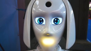 Beyaz plastikten yapılmış insansı bir robot gözlerini çevirir, ışık sinyalleri verir ve konuşur. Yapay zeka konsepti. Robotlar insan asistanlarıdır..
