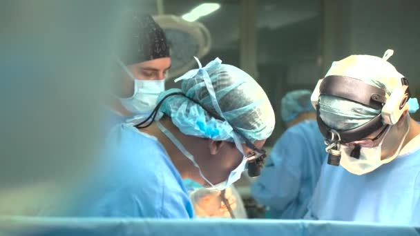 乌克兰哈尔科夫 2024年1月17日 几名医生和一名身穿军服 手里拿着手术器械的护士弯下腰给一位病人做手术 — 图库视频影像