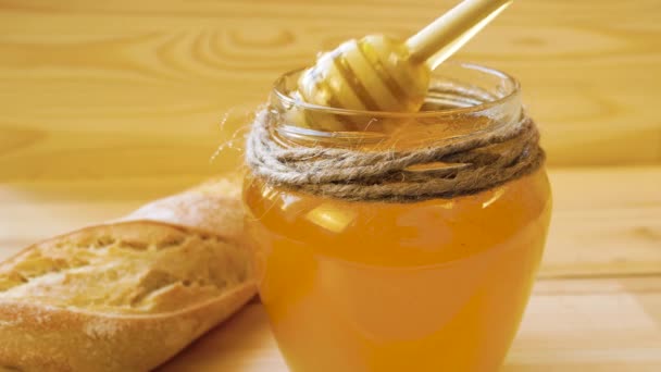 Vloeibare Honing Druipt Van Een Houten Lepel Een Pot Vlakbij — Stockvideo