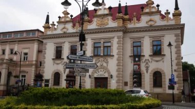 Rzeszow, Polonya - 15 Haziran 2023: Avrupa 'da eski bir tiyatro binası. Önde yol yön işaretleri olan bir çiçek tarhı var. Küçük bir Avrupa şehrinin hayatı.