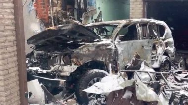Konut binasının avlusuna atılan füze saldırısından sonra yanmış ve parçalanmış bir araba. Rus-Ukrayna savaşı.