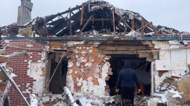 Kharkiv, Ukrayna - 25 Ocak 2024: Köpekli bir adam Rus ordusunun füze saldırısından sonra evinin önünde duruyor. Ukrayna köylerinin bombalanması. Rus-Ukrayna savaşı.