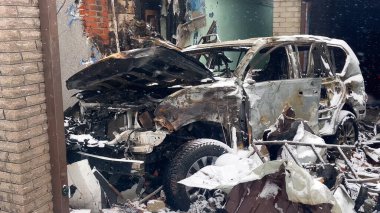 Konut binasının avlusuna atılan füze saldırısından sonra yanmış ve parçalanmış bir araba. Rus-Ukrayna savaşı.