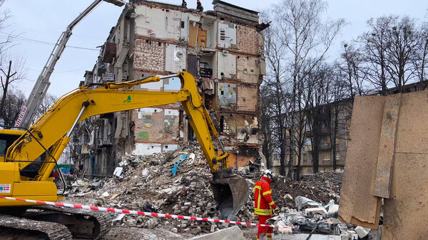 Kharkiv, Ukraine - January, 23, 2024: An excavator clears the rubble of a collapsed residential building. The consequences of a missile attack on a residential building in a Ukrainian city. Russian