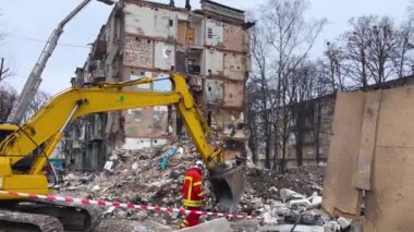 Kharkiv, Ukrayna - 23 Ocak 2024: Bir kazıcı çökmüş bir konut binasının enkazını temizliyor. Ukrayna 'da bir yerleşim yerine yapılan bir füze saldırısının sonuçları. Rusça