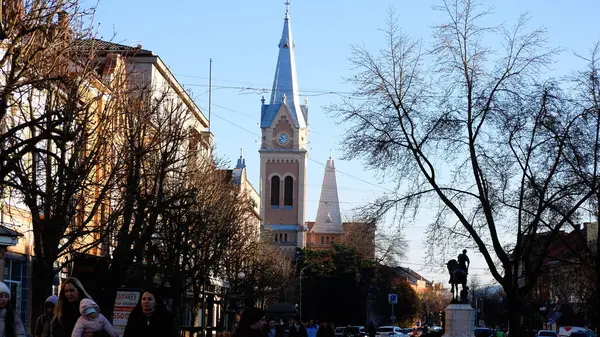 乌克兰穆卡切夫 2024年1月11日 人们沿着欧洲一个古老城镇的人行横道行走 前面有一座高塔的教堂 城市气氛 — 图库照片