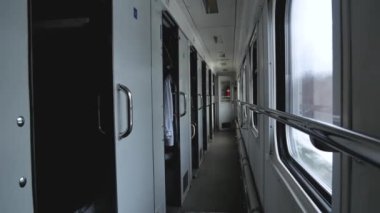 Gece uyuyan yolcu treninin koridoru. Pencereden geçen manzarayı görebiliyorsun. Arabanın ayrı kompartımanları olan kapıları var..