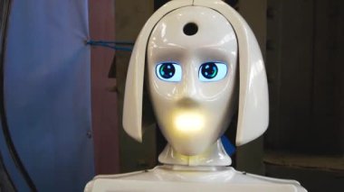 Beyaz plastik bir robotun kafası konuşurken ışıkları yakar, başını çevirir, gözlerini çevirir. Yapay zeka kavramı. Robot danışmanı.