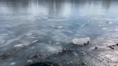 Kışın donmuş göl. Kıyıya yakın saydam buz parçaları. Göl kıyısında kış manzarası.