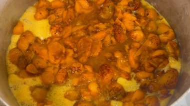 Tencerede kayısı reçeli, yukarıdan görüntü. Ocağın üstünde bir tencerede kokulu portakal böğürtlen ve köpük. Tatlı bir tatlı hazırlıyorum..