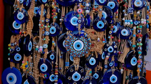 stock image Many amulets of the Turkish eye hang on a stand in a souvenir shop. Panorama.