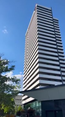 Uzun bir gökdelen, gökyüzüne karşı modern bir iş merkezi. Şehir mimarisi.