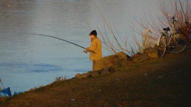 Mukacheve, Ukrayna - 11 Ocak 2024: Elinde olta olan bir adam, nehir kıyısında bir balıkçı. Hobi olarak balık tutmak..
