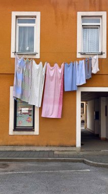 Bir Avrupa şehrinin küçük bir avlusunda yatak örtüsü pencerenin dışında kuruyor. Islak çamaşırlar rüzgar tarafından geliştirilir..