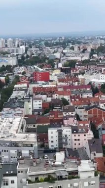 Kırmızı çatıları ve yüksek binaları olan büyük, yoğun bir Avrupa şehri. Manzara, manzara. Ufukta dağlar ve ormanlar görülebilir. Büyük bir şehirde hayat.