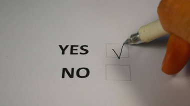 Kalemli bir el oy pusulasında evet ya da hayır sütununu seçer ve evet kelimesinin yanına bir işaret koyar. Bir seçmen seçimini Birleşik Devletler başkanlık seçiminde yapar. Yapılan seçimler konsepti.