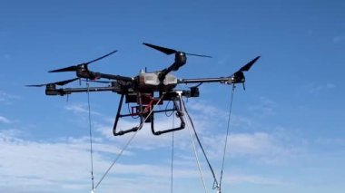 Bir tarlanın üzerinde büyük bir tarımsal dron yükseliyor. Havadan tarımsal alan ekimi.