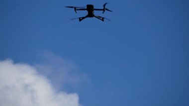 İHA bulutların arasında gökyüzünde uçuyor. Gökyüzünden fotoğraf ve video çekimi. Askeri operasyonlarda keşif dronu.