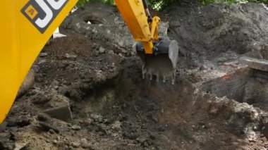 Kharkiv, Ukrayna - Haziran 08, 2024: Kazı kovası bir çukurdan toprağı kazıyor. Makinelerin yardımıyla yer işleri..