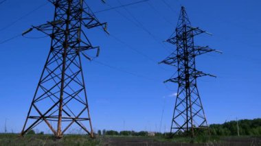Mavi bir gökyüzünün arka planında yüksek voltajlı elektrik hattının yüksek kolonları. Elektrik üretimi ve tüketimi kavramı, yeşil enerji. Nükleer enerji ve istikrarlı elektrik kaynağı. Enerji
