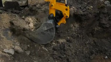 Kharkiv, Ukrayna - Haziran 08, 2024: Bir kazıcı kovayla kazarak toprağı delikten çıkarır. Bir kazıcı kullanarak yer işleri.