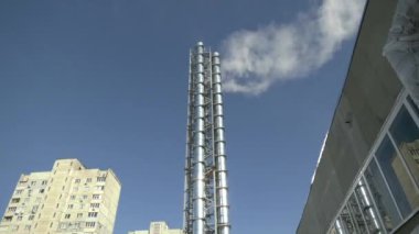 Bir yerleşim bölgesindeki küçük bir kazan dairesinin yüksek boruları. Şehirde termal jenerasyon. Termal üretimin ademi merkeziyeti.