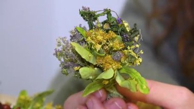 Kadınların elleri çay demlemek için bir buket kurutulmuş tarla bitkisi tutar. Sıcak çay, bitki çayı..