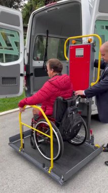 Zagreb, Hırvatistan - 21 Eylül 2024: Bir asansör tekerlekli sandalyedeki bir adamı bir minibüsün kabinine kaldırdı. Kas-iskelet engelli insanlar için şehirde erişilebilirlik.