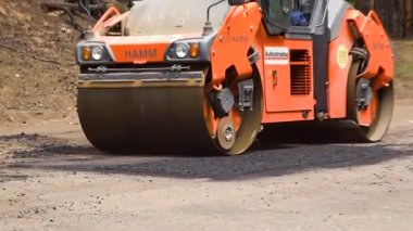 Kharkiv, Ukrayna - 22 Ekim 2023: Asfalt kaldırım ya da asfalt makinesi hasarlı asfalt yerine bitumen bırakır. Patenler yeni asfaltı düzleştirir ve sıkıştırır. Yol yüzeyi onarımı.