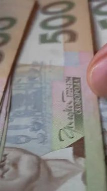 Tanınmayan eller Ukrayna Hrivnia 'sının banknotlarını sayıyor. Ukrayna para birimiyle nakit ödemeler. Ukrayna 'da enflasyon artışı, yükselen ürün fiyatları. Nüfusun yoksullaşması