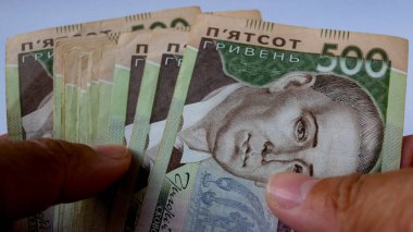 Ellerinde beş yüz Ukrayna hrivniası olan bir sürü banknot var. Artan fiyatlar, yükselen enflasyon ve krediler kavramı.