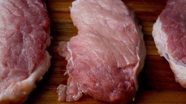 Mutfak tahtasındaki kırmızı taze et parçaları. Domuz eti pişiriyorum..