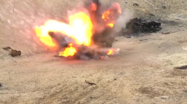 Kumlu atık sahasında büyük bir bomba patladı. Flaş, duman. Arka planda yanmış bir araba var. Gerçek bir savaş. Savaş eylemleri. Mayınlarla bombardıman, çoklu roket atarlar. Rus-Ukrayna savaşı.