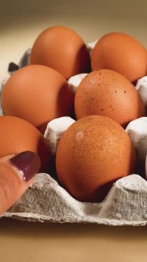 Tanınmayan bir dişi, tavuk yumurtalarını paket halinde taşır. Yumurta pişirme. Üretim, kıtlık, yumurta fiyatlarındaki artış