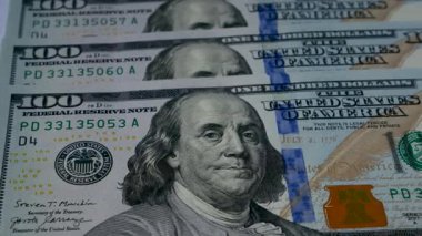 Beyaz arka planda yüz dolarlık banknotlar, panorama. Yatırım konsepti, finansal beklentiler, finansal okuryazarlık. Finansal piyasalar, enflasyon, gümrük tarifeleri, mali takaslar.