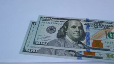 El masaya 100 dolarlık banknotlar koyar, parayı sayar. Finansal okuryazarlık kavramı, ev bütçesi. Enflasyon ve para kaybı. Dolar değişiminin düşüşü ve büyümesi