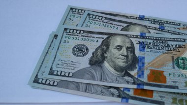 El masaya 100 dolarlık banknotlar koyar, parayı sayar. Finansal okuryazarlık kavramı, ev bütçesi. Enflasyon ve para kaybı. Dolar değişiminin düşüşü ve büyümesi