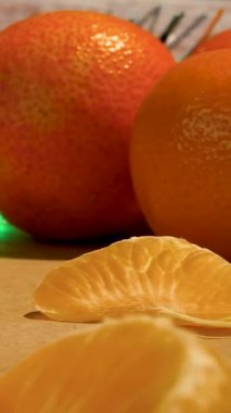 Olgun mandalinalar, masada mandalina dilimleri, arka planda şenlik bulanıklığı..