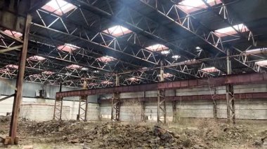 Hangar yok edildi, güneş ışınları çatıdaki deliklerden geçiyor. Panorama. Eski terk edilmiş sanayi hangarları.