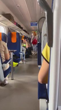 Varşova, Polonya - 22 Eylül 2024: yolcu treni. Sırt çantalı bir kadın koridorda yürüyor, etrafa bakıyor, koltuğunu arıyor. Seyahat, ulaşım, yolculuk.
