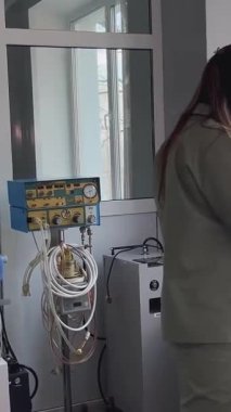 Kharkiv, Ukrayna - Şubat 01, 2024: Bir doktor hastane odasında duruyor ve tıbbi ekipmanları bir kutuya koyuyor. Yanındaki masa bebekler için. Hastanenin işi..