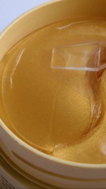 Bir kadın eli, cam bir çubukla paketten yüz derisi için jel yamaları alır. Yüz bakımı konsepti, evdeki kozmetik prosedürler. Gözlerinin altındaki deriye dikkat et. Yüze karşı savaş