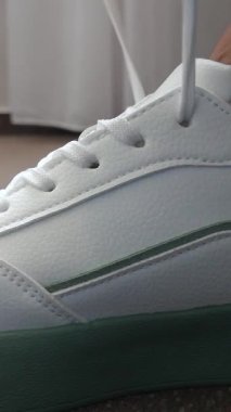 Kadınların elleri ayakkabı bağcıklarını spor ayakkabılarına bağlar. Bir kadın ayakkabıların rahat olup olmadığına bakmaya çalışır. Her gün ve spor eğitimi için kadın ayakkabıları..