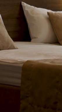 Geniş yatağı ve yumuşak yastıkları olan rahat bir yatak odasının içi. Yatağın yanında sıcak ışık ve penceresinde beyaz perdeler olan bir lamba var. Yatak odasındaki sıcak akşam atmosferi, konfor ve...