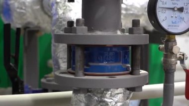 Kharkiv, Ukraine - September, 12, 2025: Interior view of a compact boiler mechanical room showing metal pipes, valves, shut-off valves and pressure sensors, technical detail for energy, HVAC and