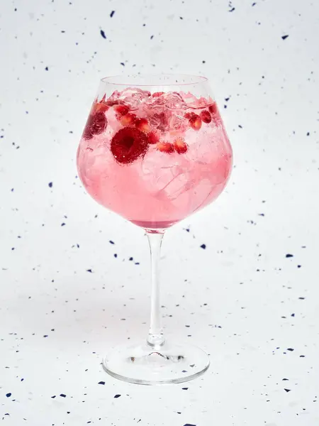 stock image Close-Up of Refreshing Pink Gin Tonic with Berries against a speckled background