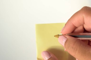 Elleri boyalı, beyaz arka planda boş mektup kağıdı tutan bir kadın eli..