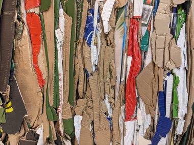 A large stack of waste paper from pressed cardboard boxes is sorted and packed for paper recycling. Sorting garbage. Secondary use of resources. Raw materials for the pulp industry.