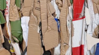 A large stack of waste paper from pressed cardboard boxes is sorted and packed for paper recycling. Sorting garbage. Secondary use of resources. Raw materials for the pulp industry.