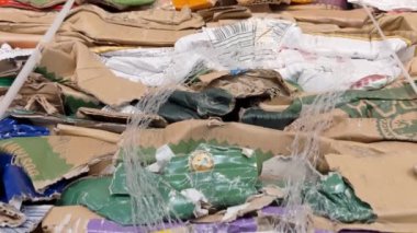 A large stack of waste paper from pressed cardboard boxes is sorted and packed for paper recycling. Sorting garbage. Secondary use of resources. Raw materials for the pulp industry.